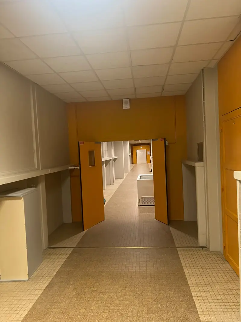 Couloir carrelé avec portes peintes